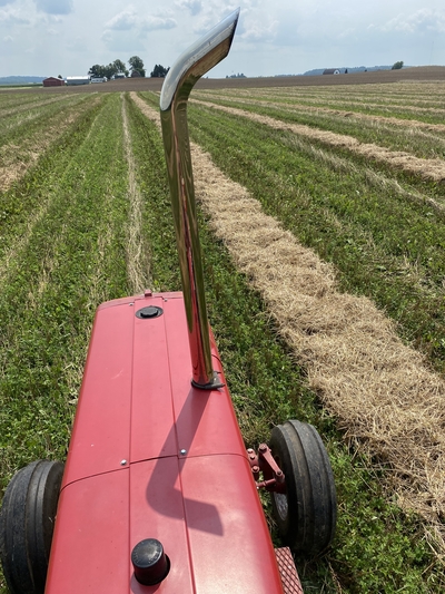Tractor with rows of straw in a field at SCF in Bloomer, WI
