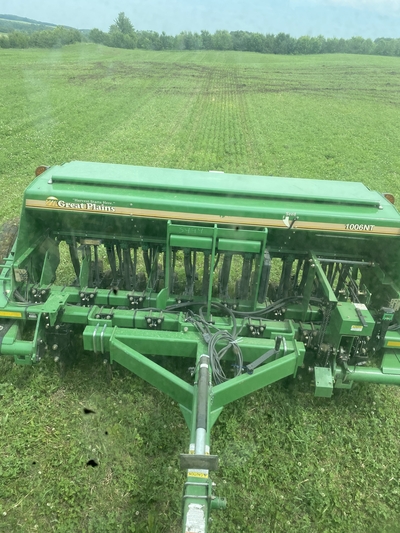 Grain drill planting a green field in Bloomer, WI